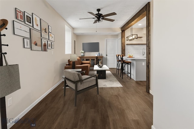 living area with hardwood / wood-style flooring, ceiling fan, and a textured ceiling