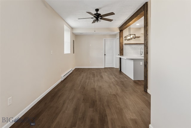 hall with dark wood-type flooring, a baseboard radiator, a textured ceiling, and sink