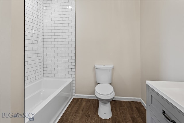 full bathroom with hardwood / wood-style floors, vanity, toilet, and tiled shower / bath combo