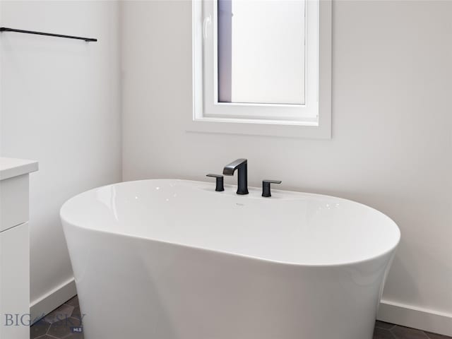 bathroom with tile patterned flooring, vanity, and a bathing tub