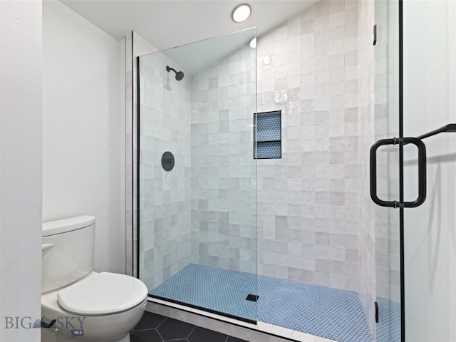 bathroom featuring tile patterned flooring, a shower with door, lofted ceiling, and toilet