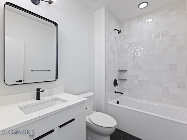 full bathroom featuring tile patterned flooring, tiled shower / bath combo, toilet, and vanity