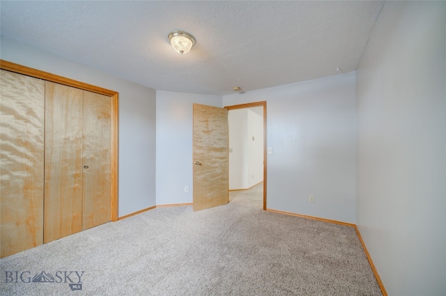 unfurnished bedroom with a closet, carpet floors, and a textured ceiling