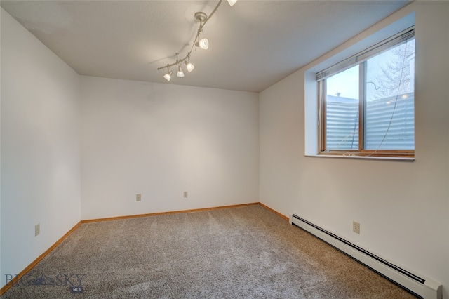 carpeted empty room with baseboard heating and rail lighting