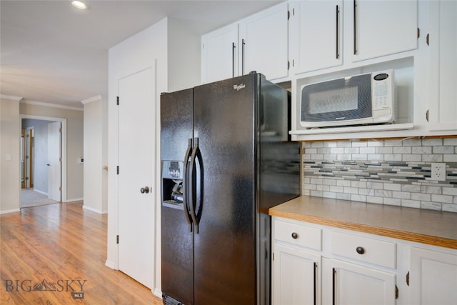 kitchen with white cabinets, light hardwood / wood-style flooring, decorative backsplash, ornamental molding, and black fridge with ice dispenser