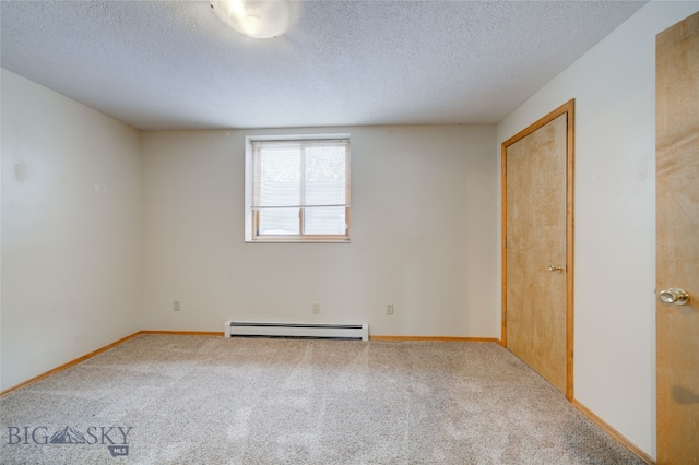 empty room with a textured ceiling, carpet floors, and baseboard heating