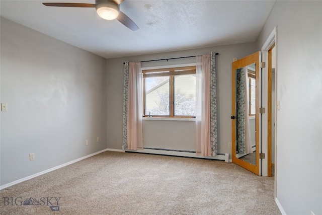 carpeted empty room featuring ceiling fan and a baseboard radiator