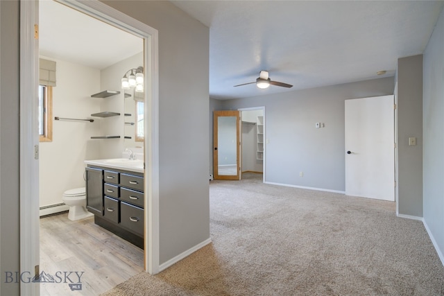 interior space with ceiling fan, plenty of natural light, vanity, and a baseboard radiator