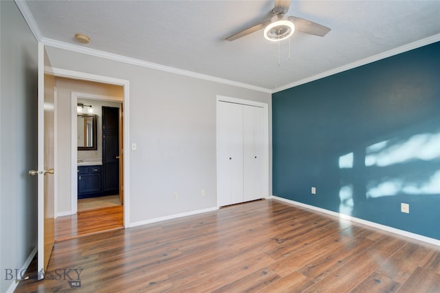 unfurnished bedroom with a closet, ceiling fan, dark hardwood / wood-style flooring, and crown molding