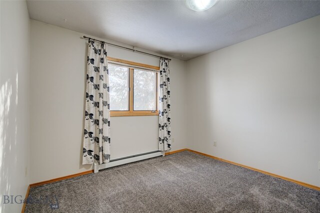 carpeted empty room with a textured ceiling and a baseboard heating unit