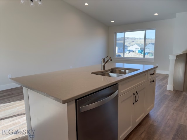 kitchen featuring stainless steel dishwasher, a kitchen island with sink, sink, wood-type flooring, and white cabinets