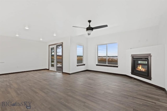 unfurnished living room featuring dark hardwood / wood-style floors and ceiling fan