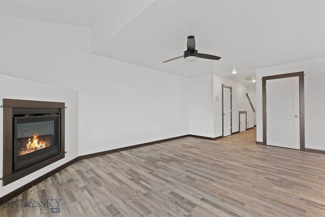 unfurnished living room with ceiling fan and light wood-type flooring