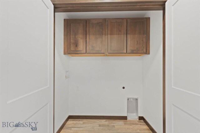 laundry area with cabinets, light wood-type flooring, and hookup for an electric dryer