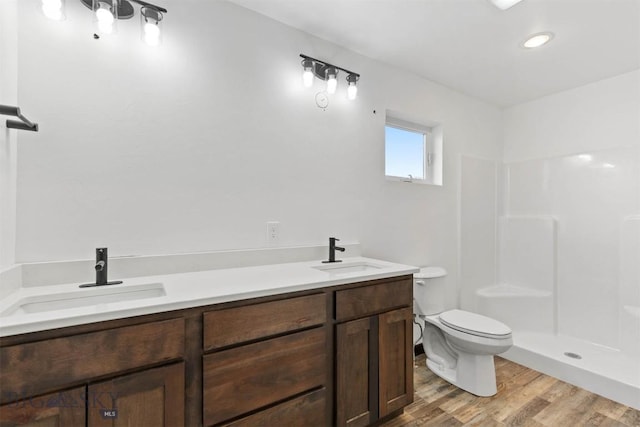 bathroom with vanity, toilet, wood-type flooring, and a shower