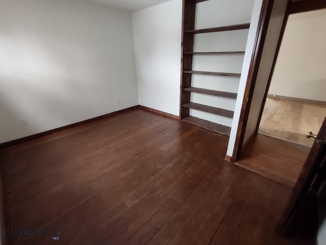 unfurnished bedroom with dark wood-type flooring