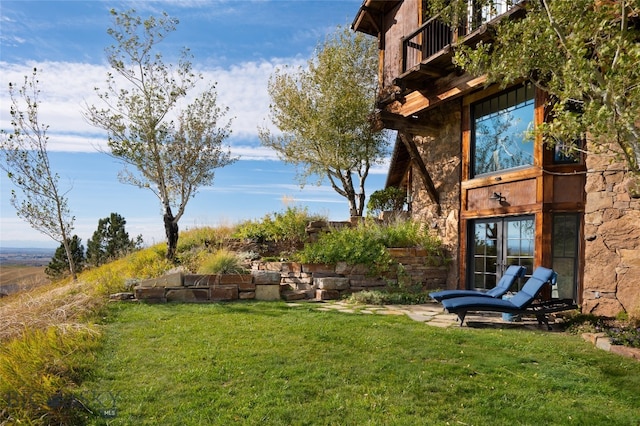 view of yard with a balcony