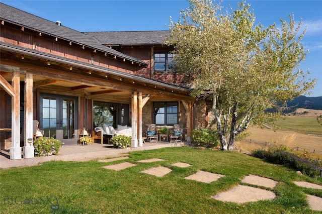 rear view of property with a yard and a patio