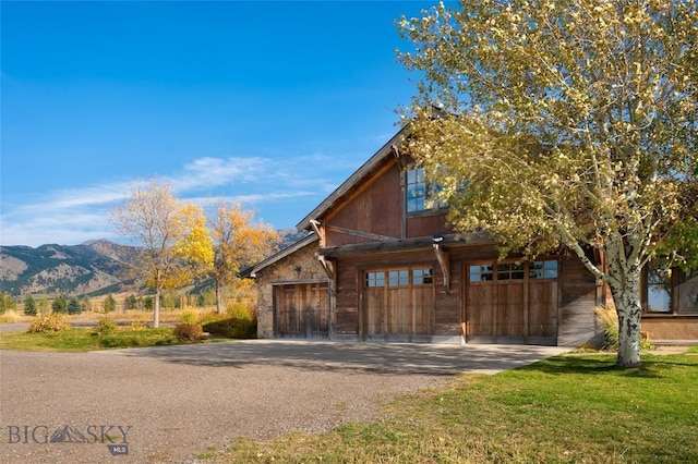 618 Autumn Ridge Rd, Bozeman, MT 59715 - view of front facade with gravel driveway, a mountain view, and stone siding