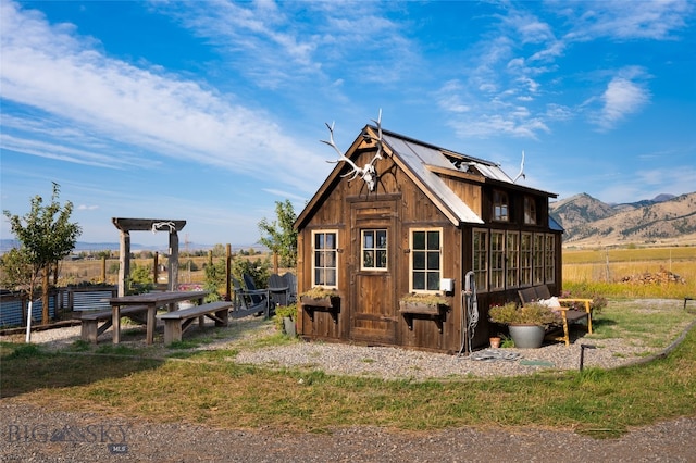 exterior space with a mountain view, a rural view, and an outbuilding