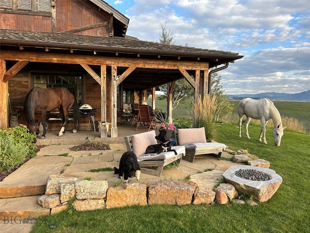 view of patio with a fire pit and a mountain view