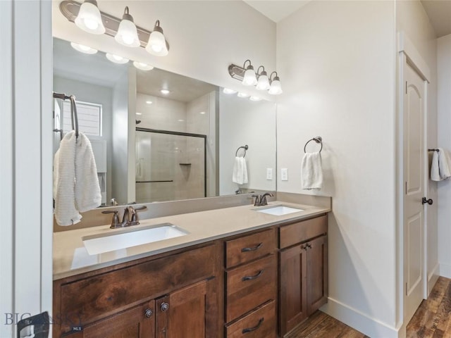 bathroom with hardwood / wood-style floors, vanity, and an enclosed shower