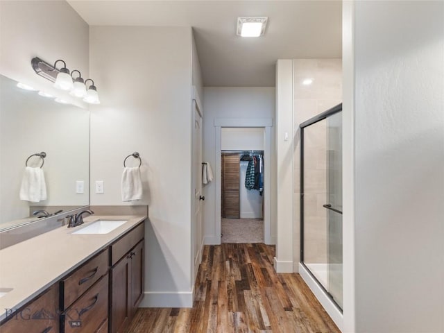 bathroom featuring hardwood / wood-style flooring, vanity, and a shower with shower door