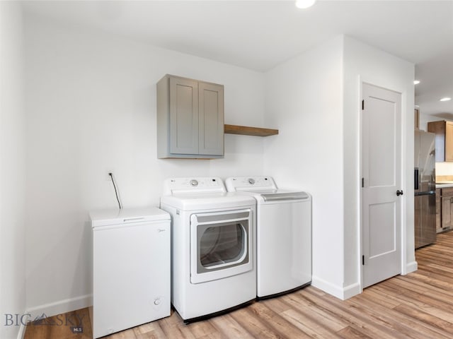 clothes washing area featuring light wood-type flooring, washing machine and dryer, baseboards, laundry area, and recessed lighting