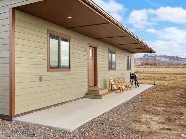 rear view of house with a mountain view and a patio
