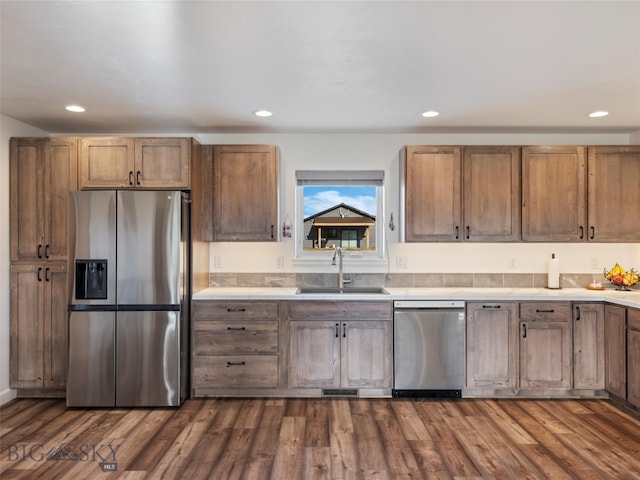 kitchen featuring a sink, light countertops, dark wood finished floors, appliances with stainless steel finishes, and recessed lighting