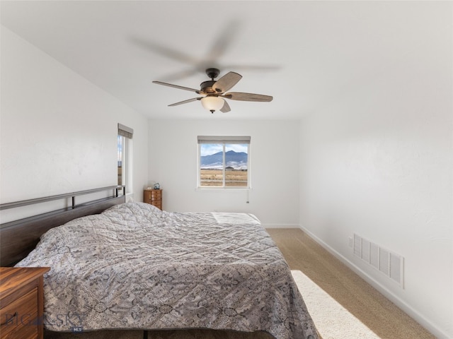 bedroom with baseboards, a ceiling fan, carpet flooring, and visible vents