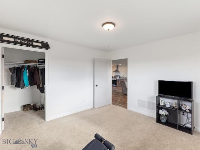 workout area featuring baseboards, visible vents, and carpet floors