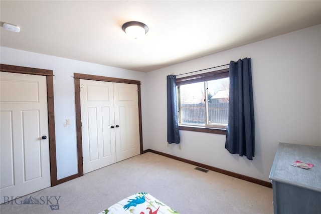 unfurnished bedroom with light carpet and a closet