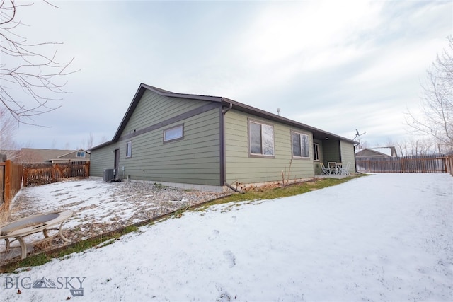 snow covered property featuring cooling unit