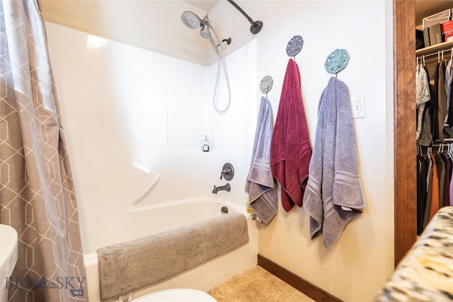 bathroom featuring tile patterned flooring, shower / bath combination with curtain, and toilet