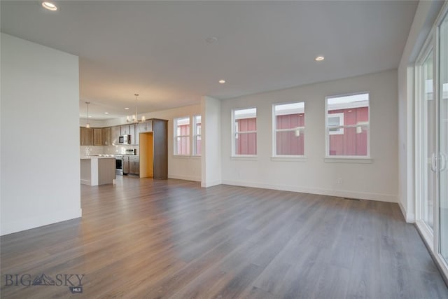 unfurnished living room with dark hardwood / wood-style flooring and an inviting chandelier