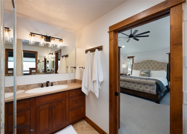 bathroom featuring ceiling fan, vanity, and a textured ceiling