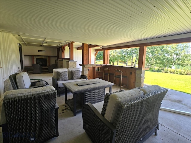 view of patio with an outdoor living space with a fireplace and an outdoor bar