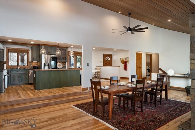 dining area featuring ceiling fan, sink, high vaulted ceiling, wood ceiling, and light wood-type flooring