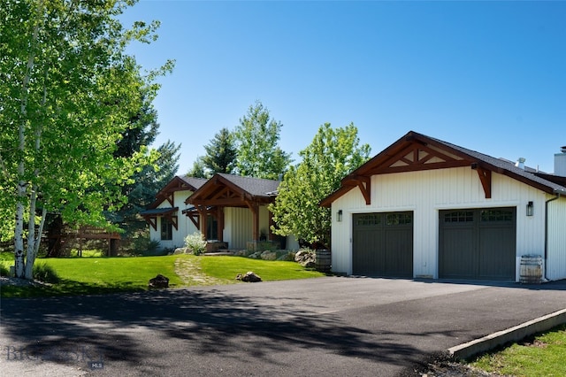 view of front of home with a front yard, an outbuilding, and a garage