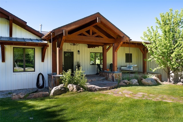 rear view of property with a porch and a yard