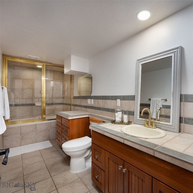 bathroom with tile patterned floors, vanity, toilet, and a textured ceiling