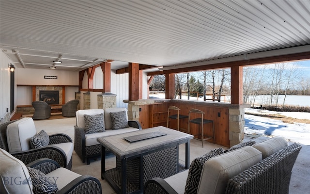 snow covered patio with an outdoor living space with a fireplace and an outdoor bar