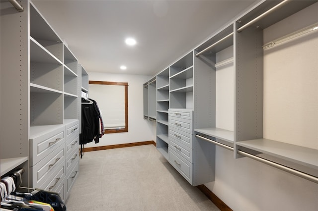 walk in closet featuring light colored carpet