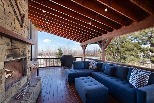 wooden terrace with an outdoor hangout area and a grill