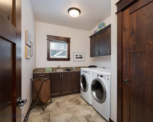 laundry area featuring sink, washing machine and dryer, and cabinets