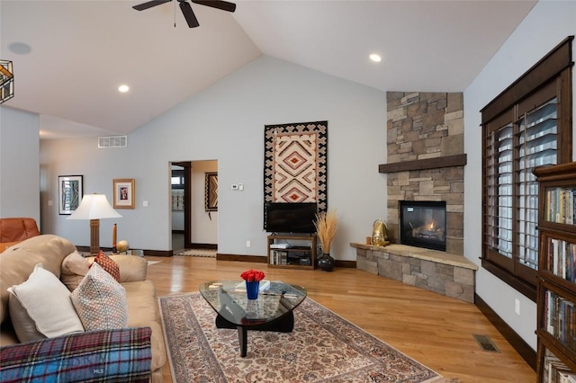 4543 Danube Ln, Bozeman, MT 59718 - living area featuring high vaulted ceiling, a ceiling fan, visible vents, a stone fireplace, and wood finished floors