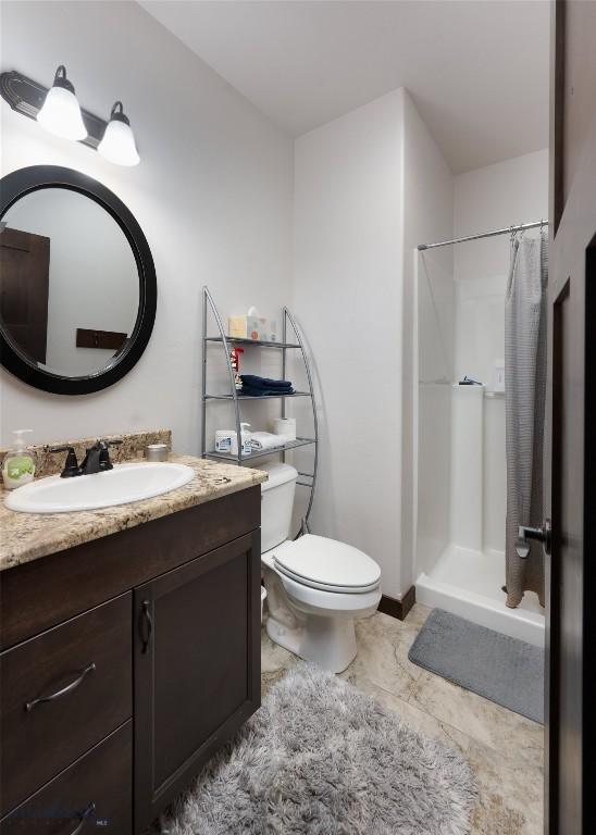 bathroom with vanity, toilet, and curtained shower