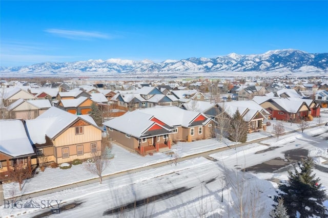 snowy aerial view featuring a residential view and a mountain view