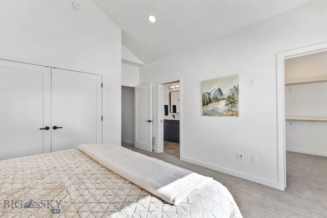 carpeted bedroom featuring high vaulted ceiling, a walk in closet, and connected bathroom